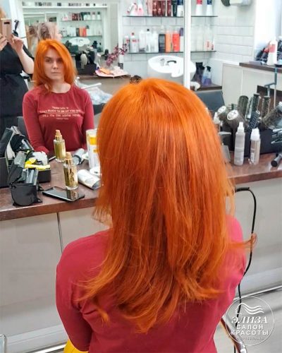 Огненно-рыжие волосы девушки окрашенные